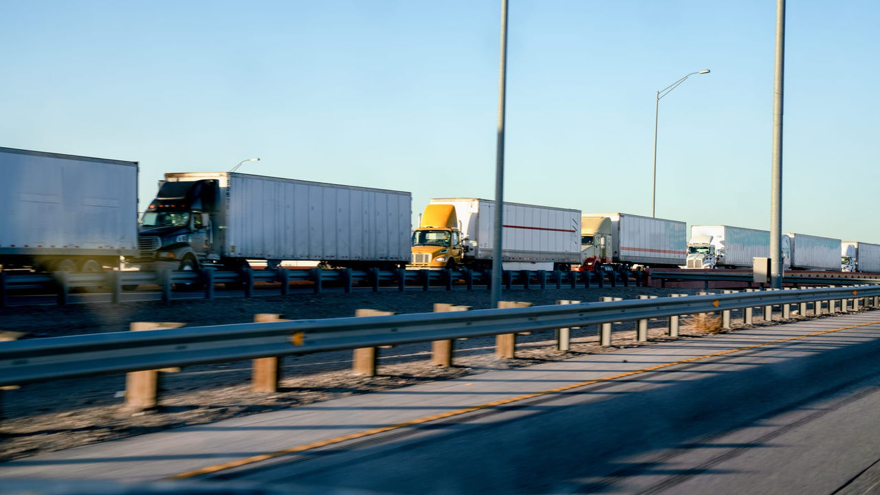 A group of trucks traveling down a highway.