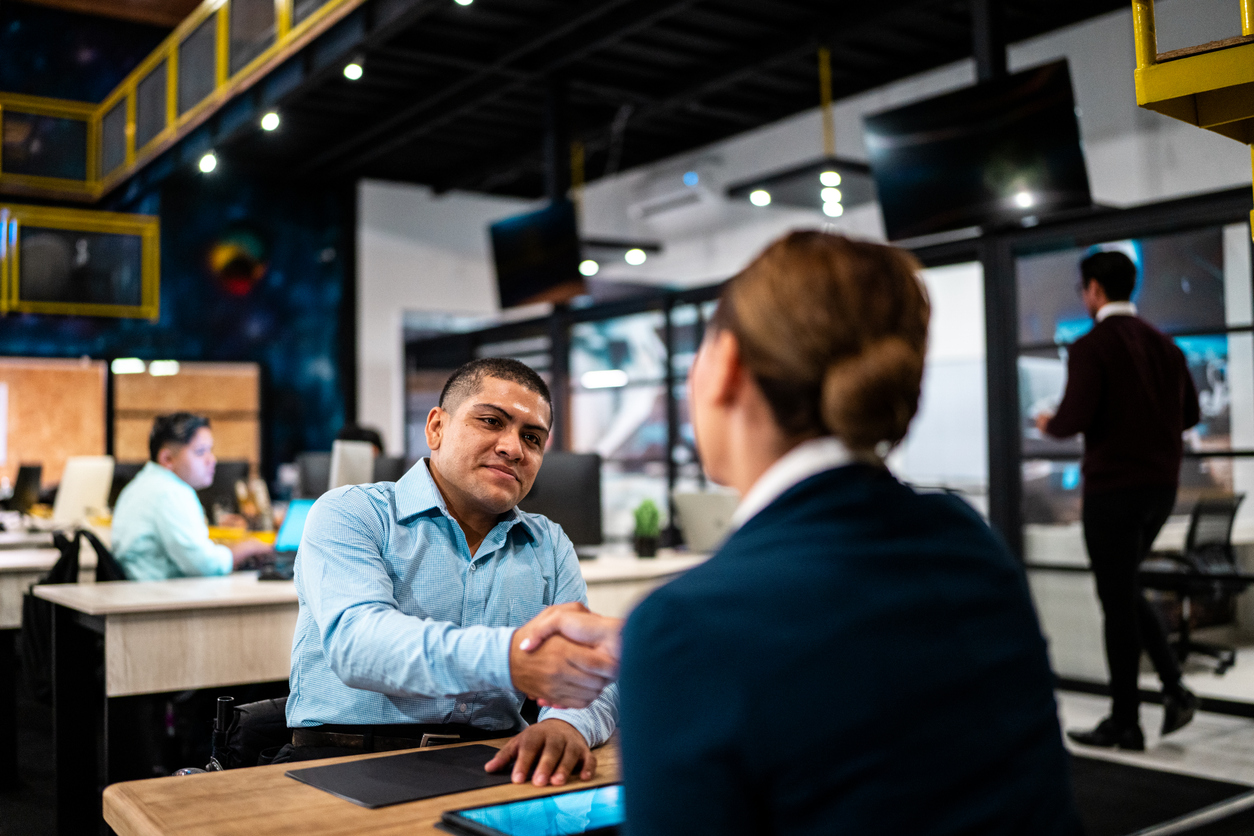 المسؤول عن التوظيف والمرشح يتبادلان التحية أثناء مقابلة العمل في المكتب