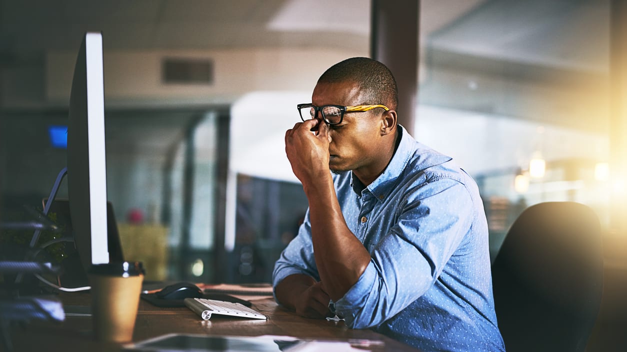 A man in glasses is looking at his computer screen.