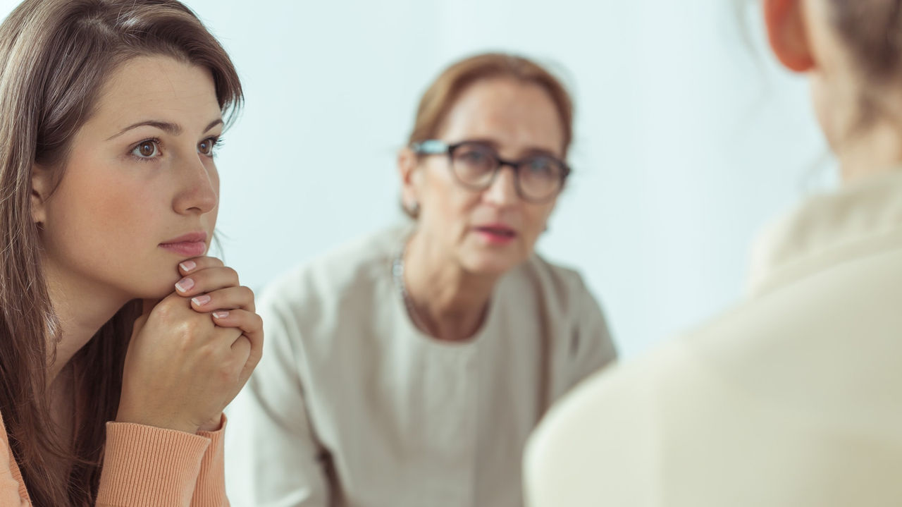 A woman is talking to an older woman in an office.