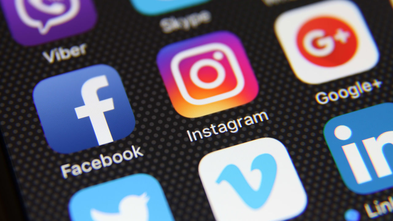Social media icons are displayed on a cell phone.