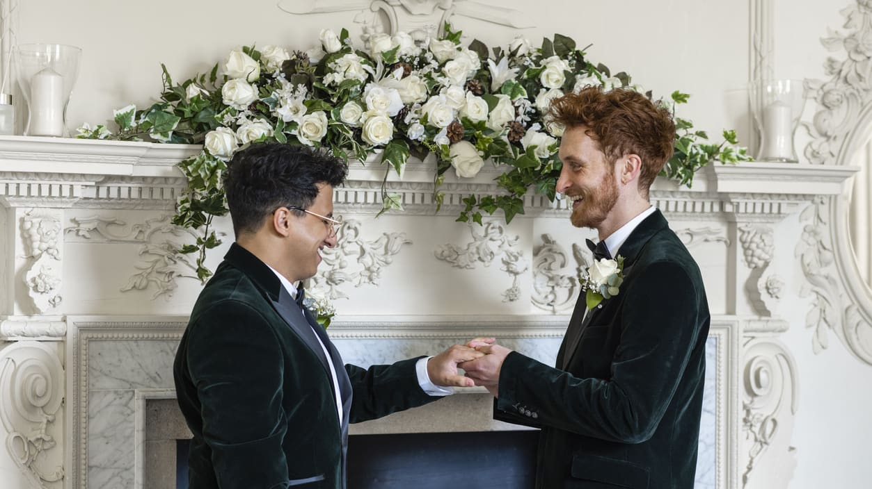 Two men shaking hands in front of a fireplace.