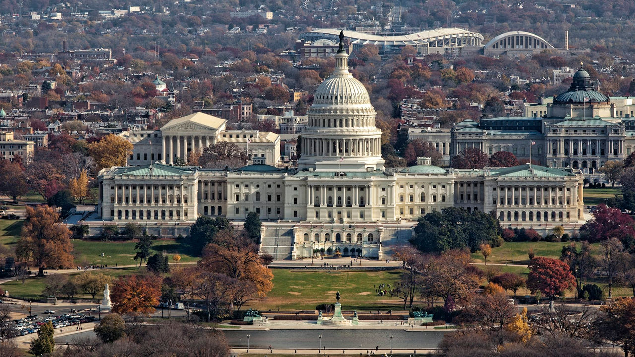 Picture taken from the air of U.S. Capitol with the Supreme Court, Library of Congress and in the distance a stadium behind it
