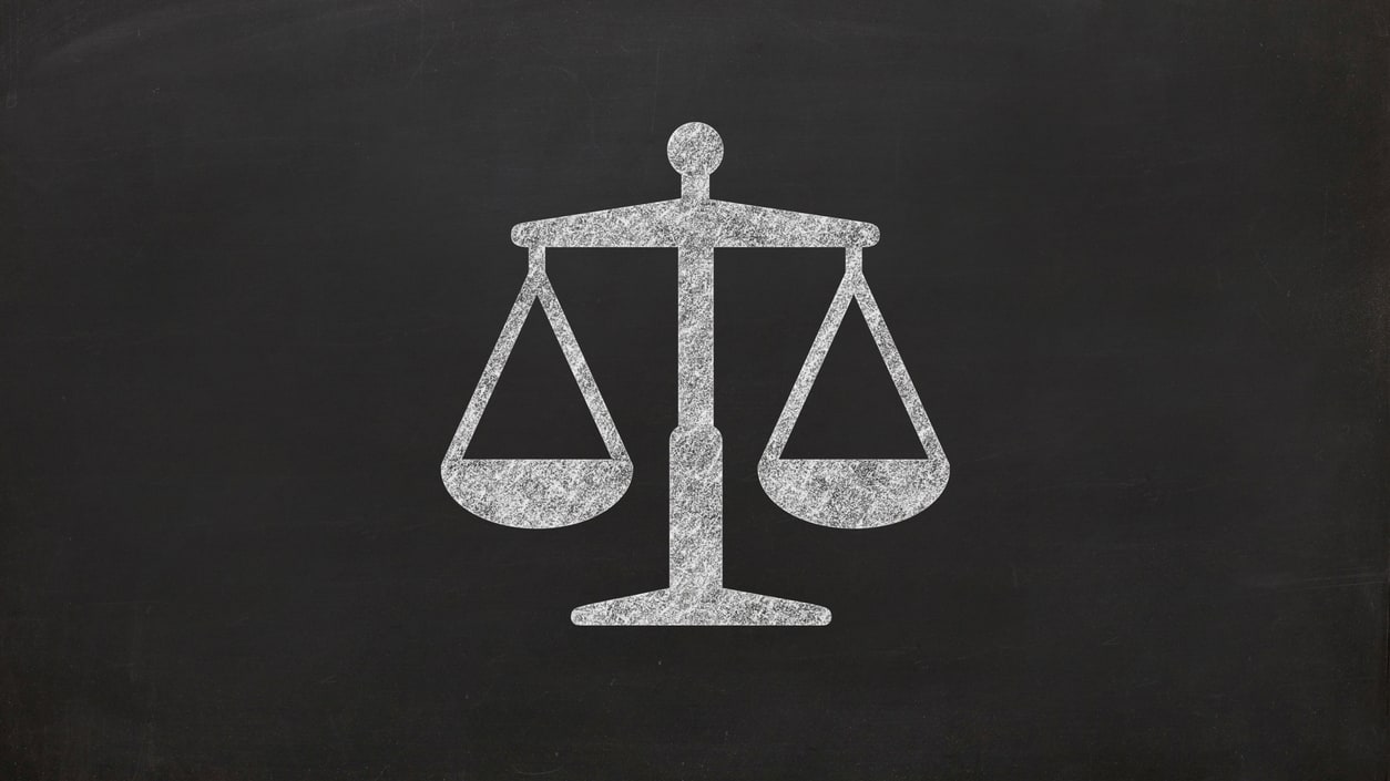 Justice scales icon on a blackboard.