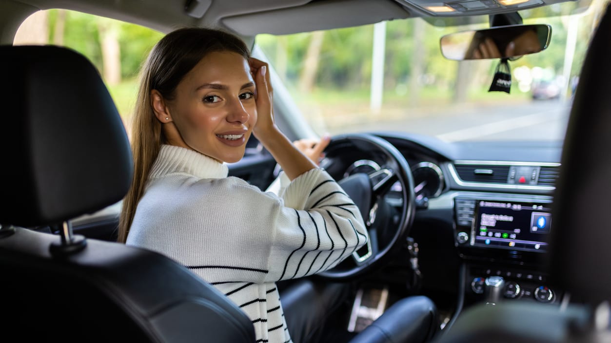 A woman sitting in the driver's seat of a car.