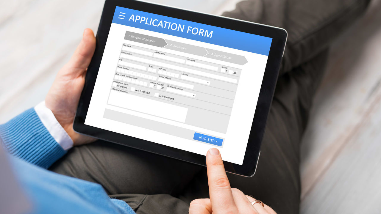 A man holding a tablet with an application form on it.