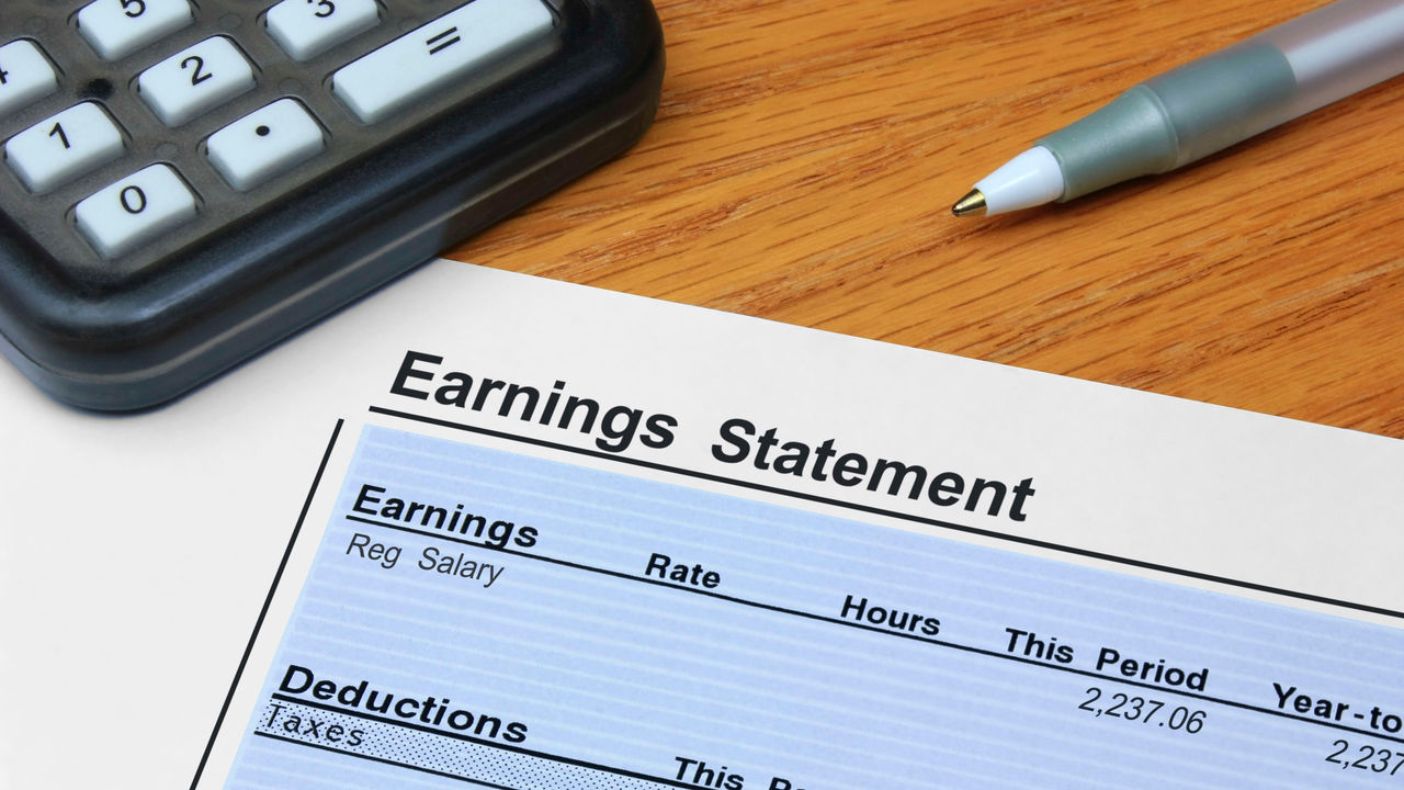 Earnings statement on a piece of paper with a calculator.