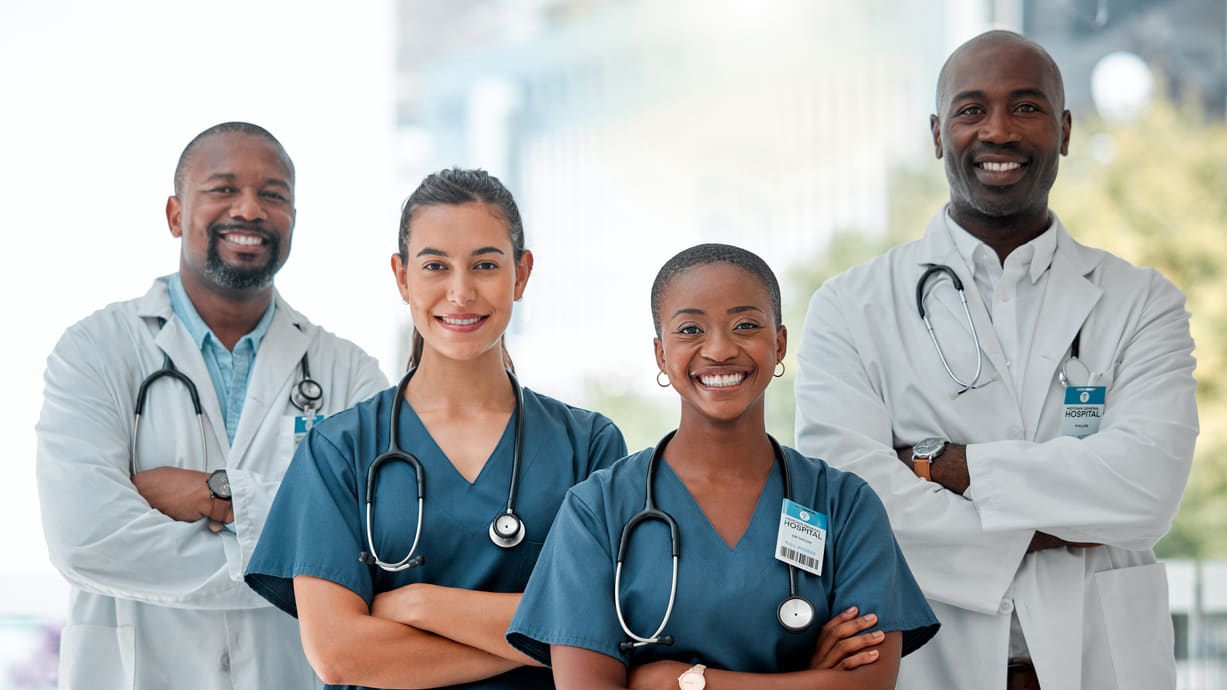 A group of doctors and nurses standing in front of a building.