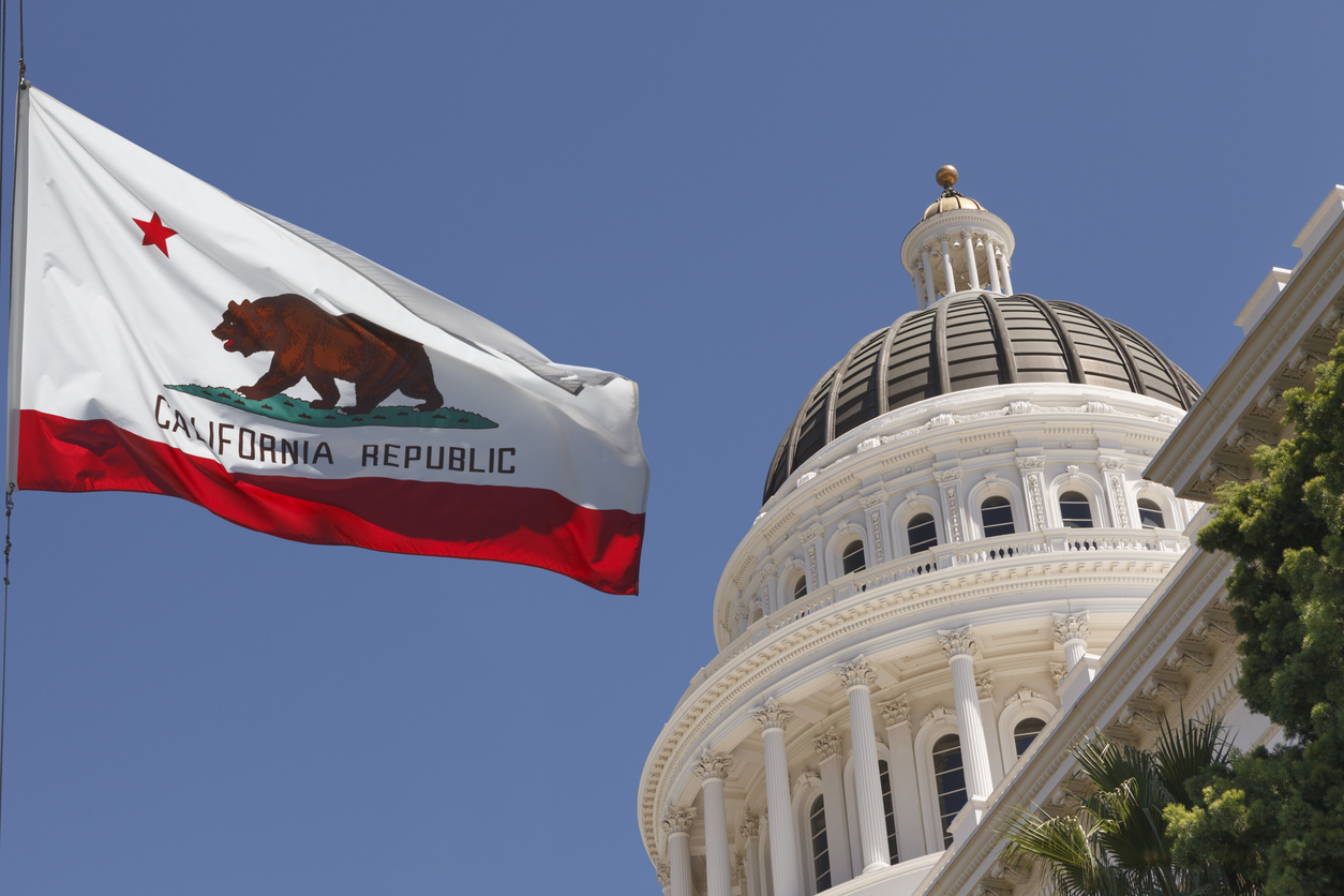 Sacramento, Calif., outside the state Capitol building with the state flag blowing in the wind on a clear day