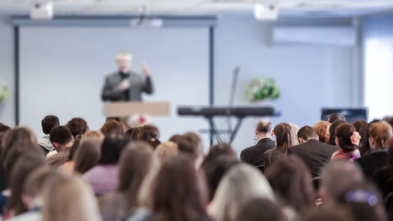 A man is giving a presentation to a large group of people.