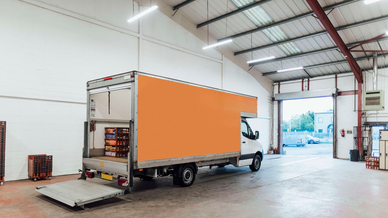 A van is parked in a large warehouse.