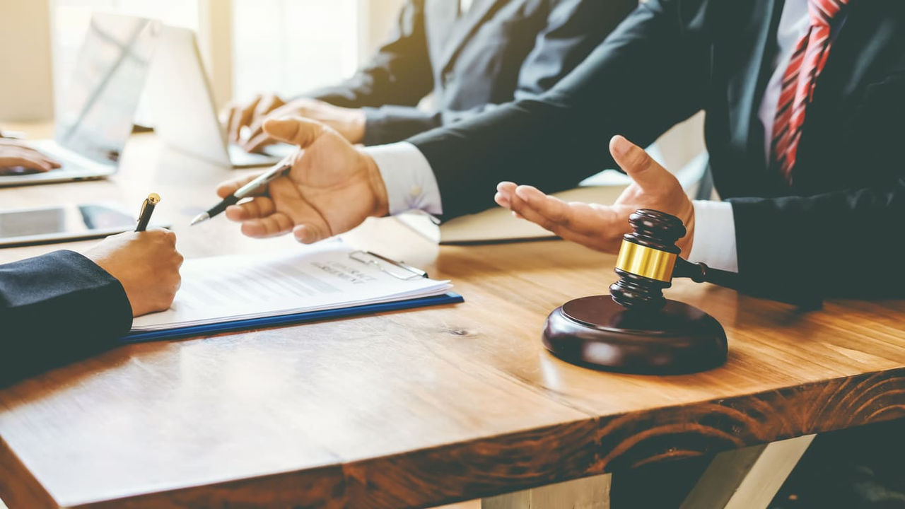 A group of business people sitting at a table with a gavel.