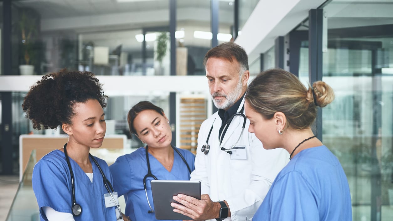 A group of doctors looking at a tablet.