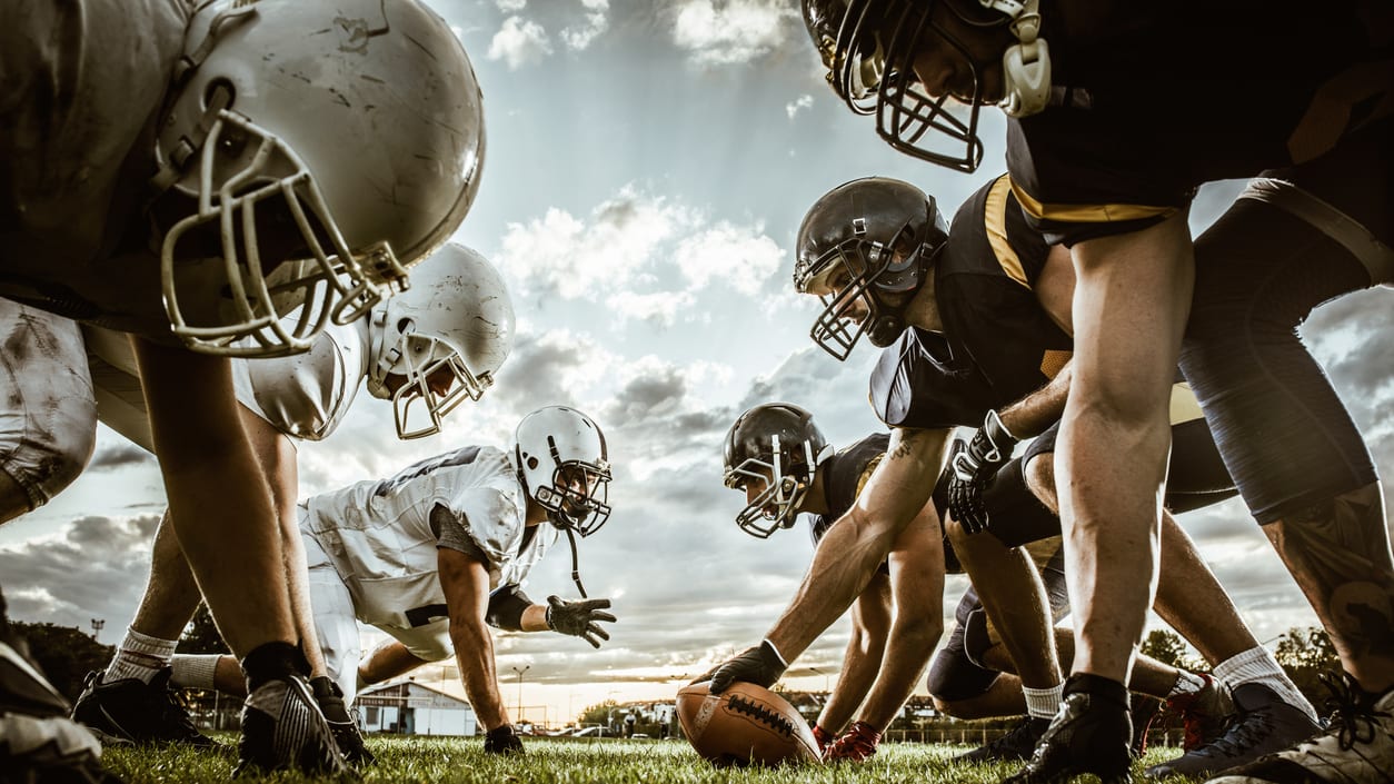 A group of football players are lined up on a field.