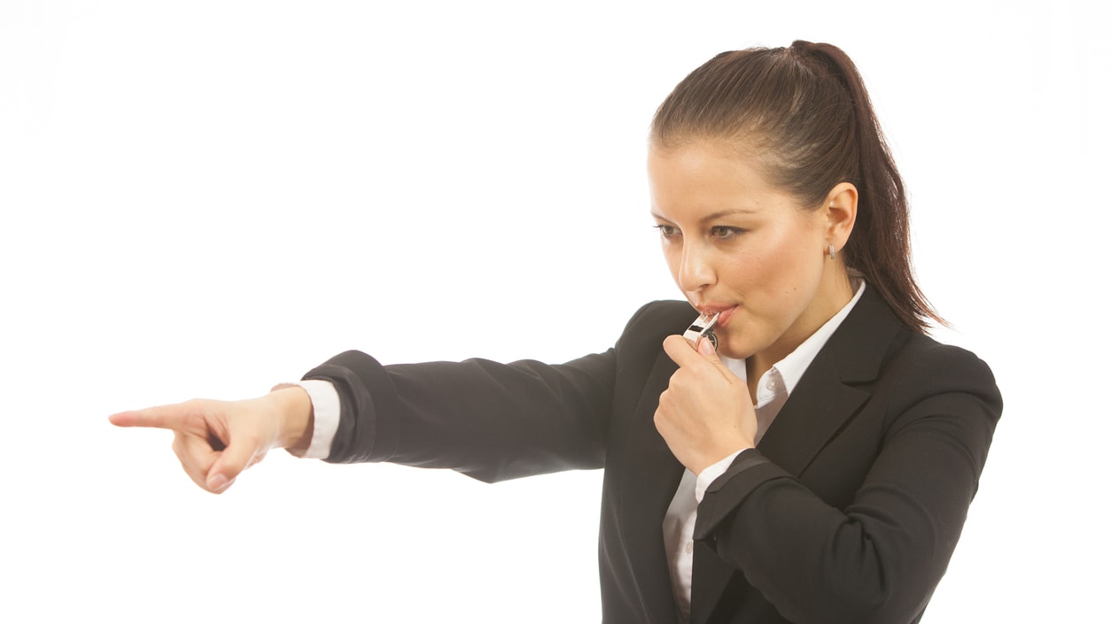 A woman in a business suit pointing her finger.