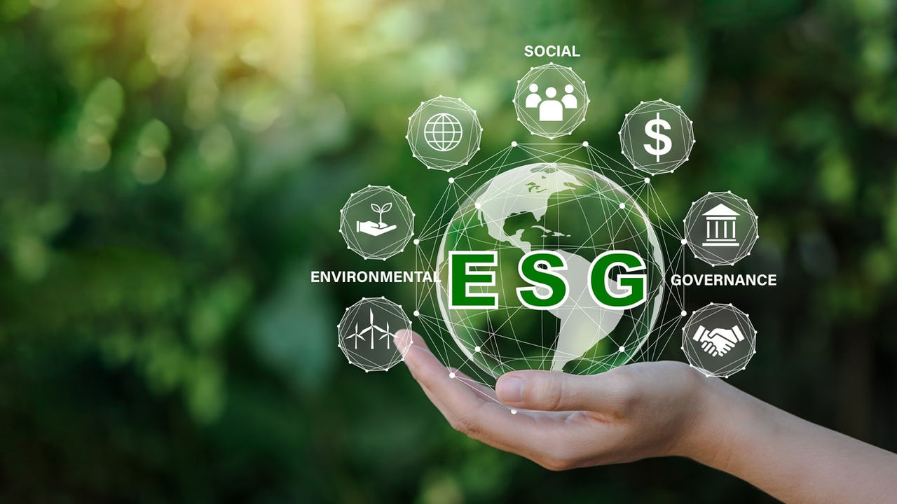 A hand holding a globe with the word esg on it.