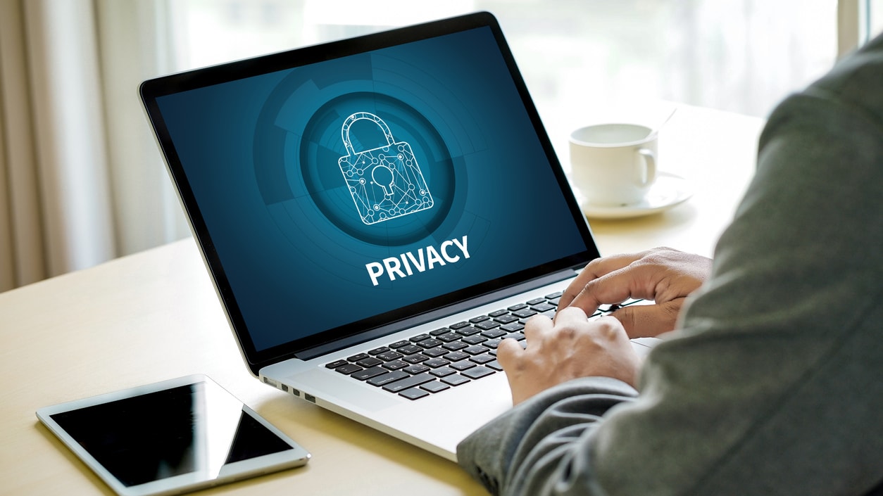 A man using a laptop with the word privacy on it.