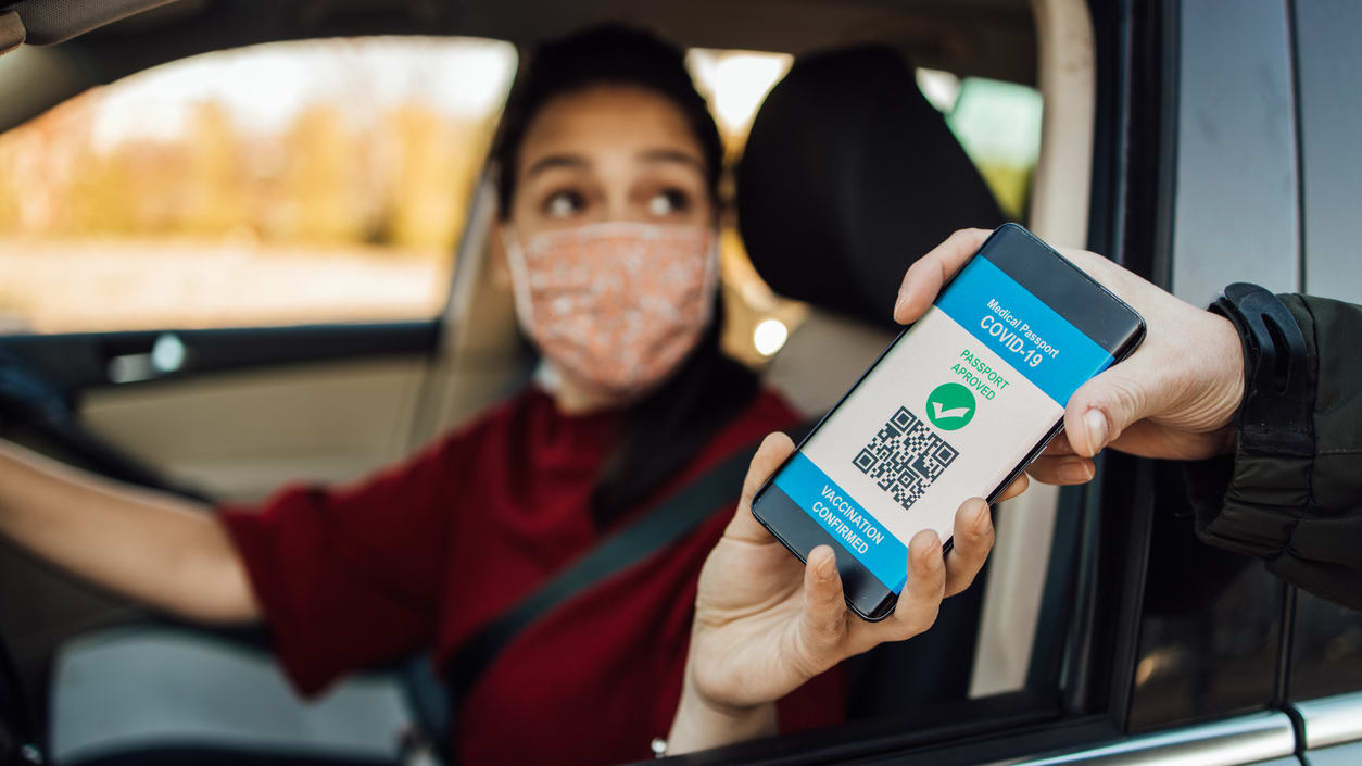 A woman in a car is using a qr code to pay for a ride.