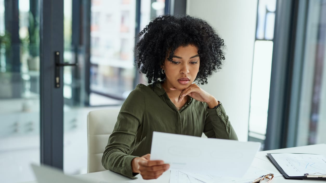A woman looking at paperwork in an office.