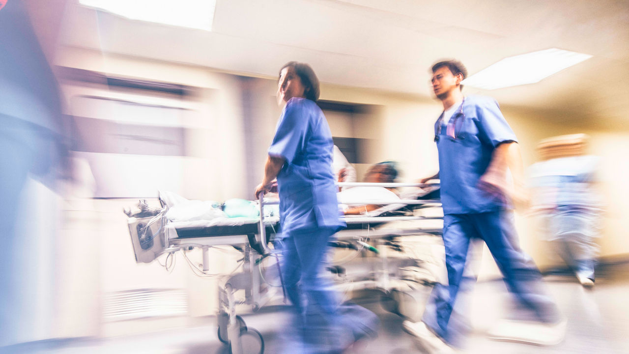 A blurry image of a group of medical workers in a hospital.