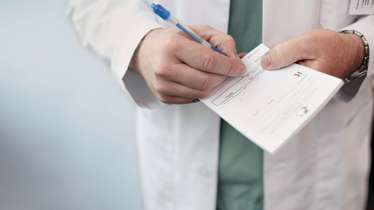 A doctor is writing on a piece of paper.