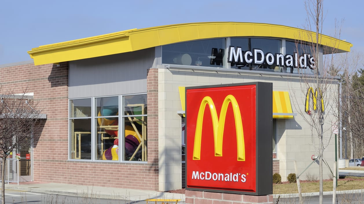 A mcdonald's restaurant with a sign in front of it.