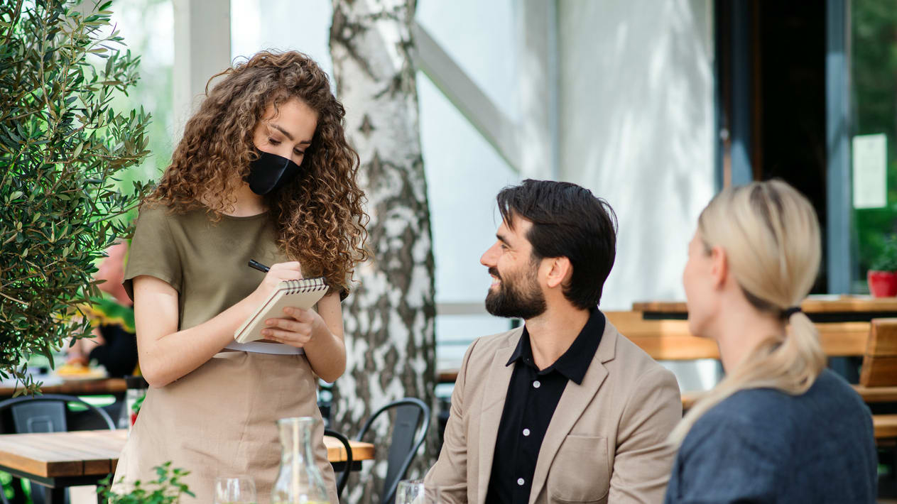 A group of people sitting at a table in a restaurant.