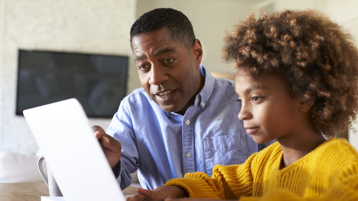 An man and his daughter using a laptop.