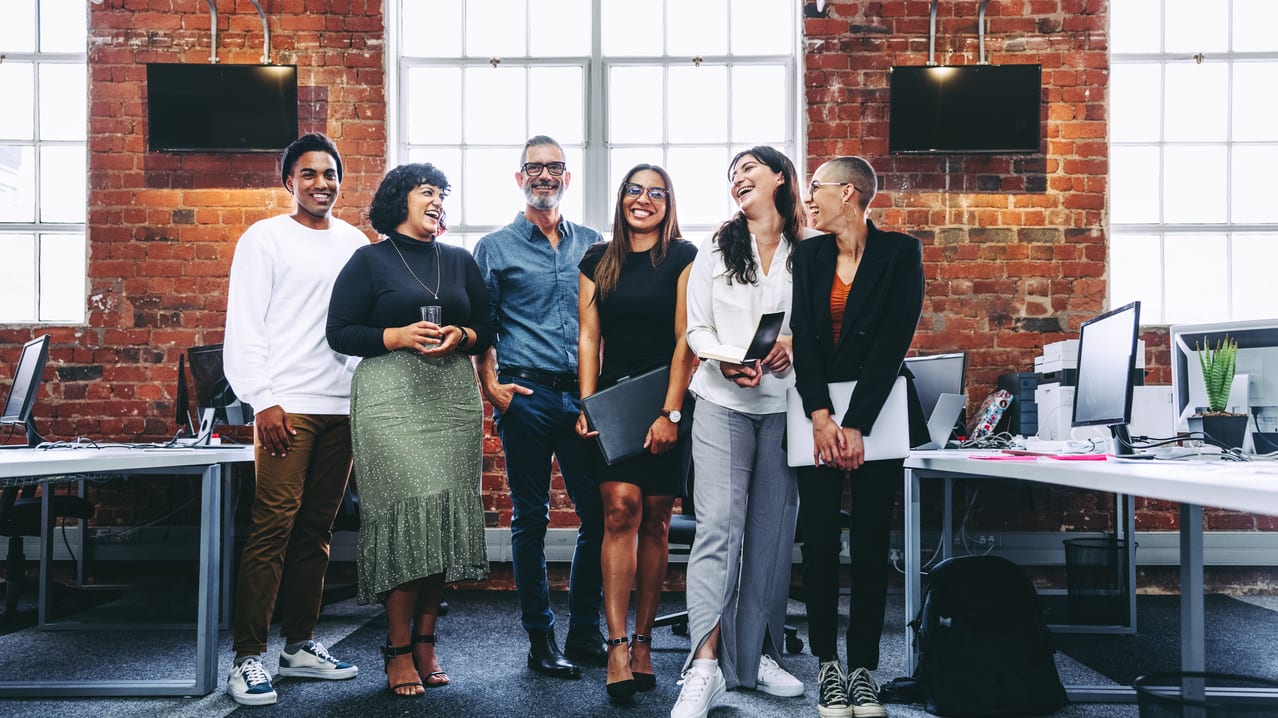 A group of business people standing in an office.