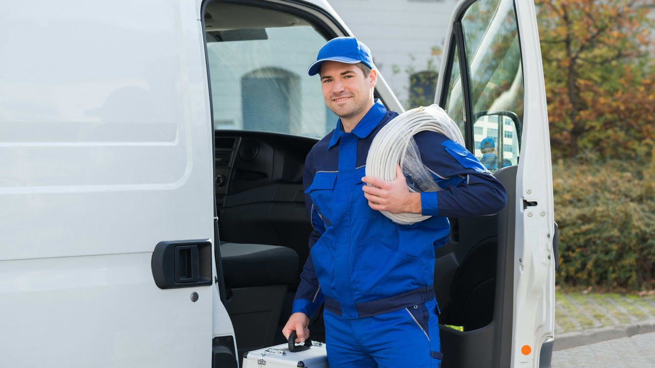 A plumber standing outside of a van.