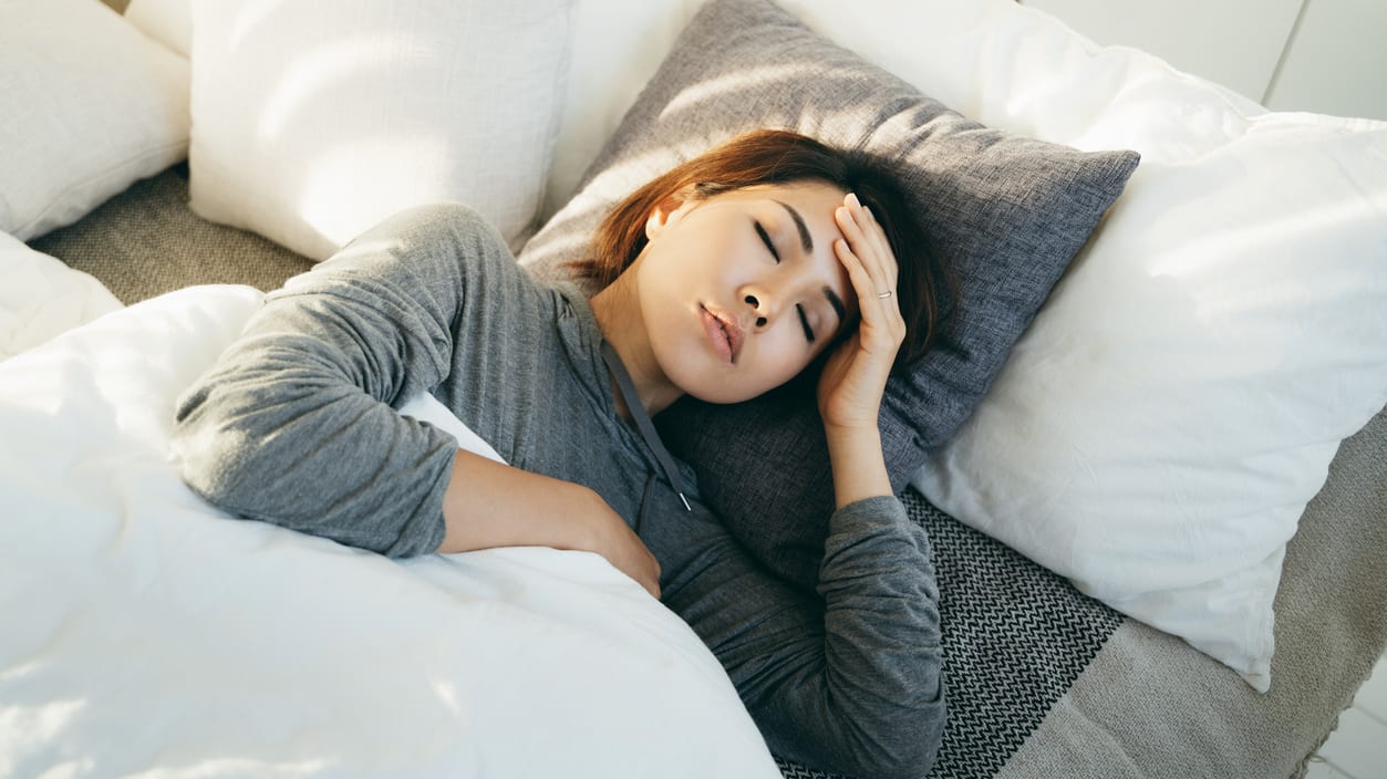 A woman is sleeping on a bed with her head resting on her head.