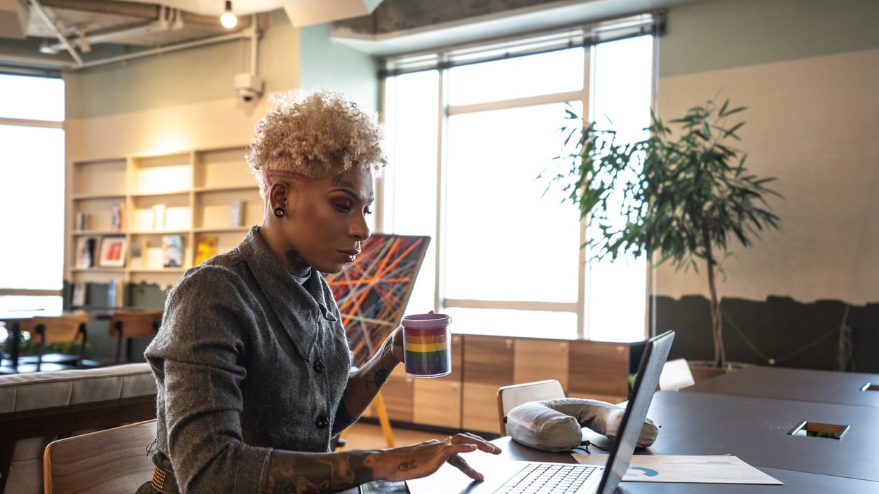 A woman working on a laptop in an office.