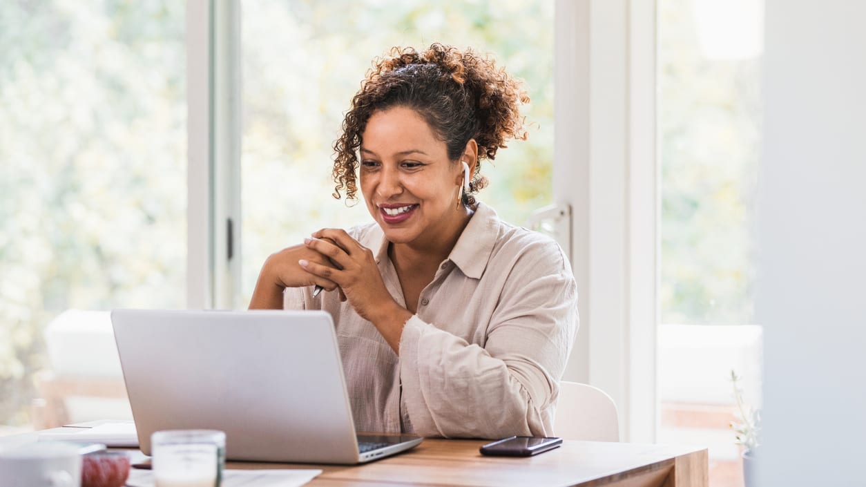 A woman sitting at a desk using a laptop.