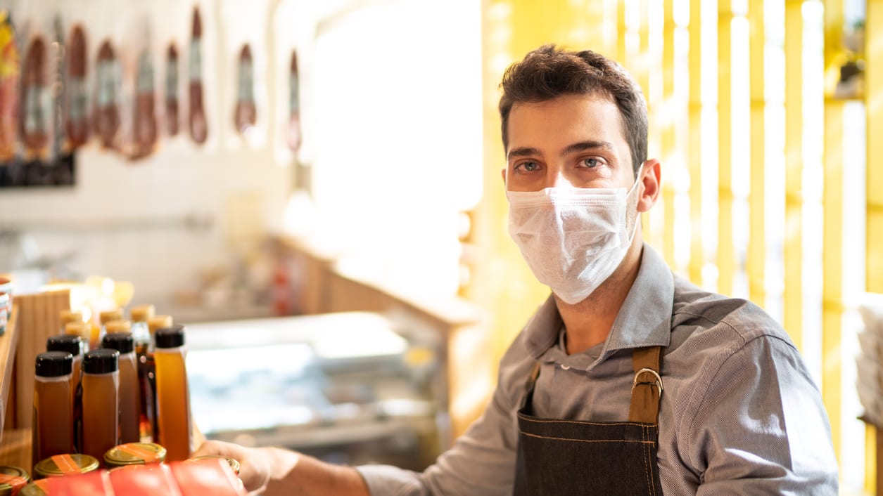 A man wearing a face mask in a shop.