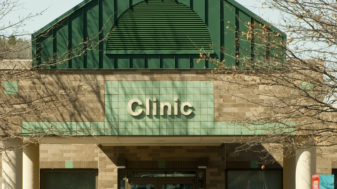A building with a green roof and a sign that says clinic.