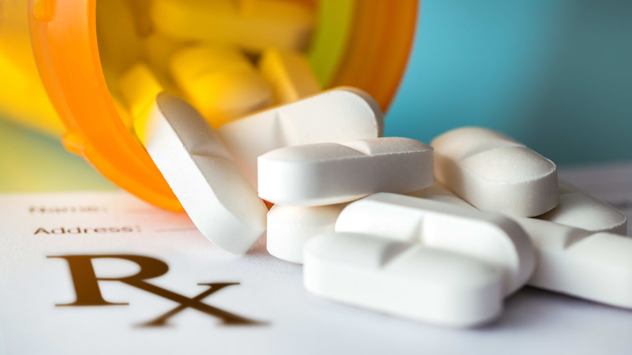 A bottle of rx pills on top of a piece of paper.