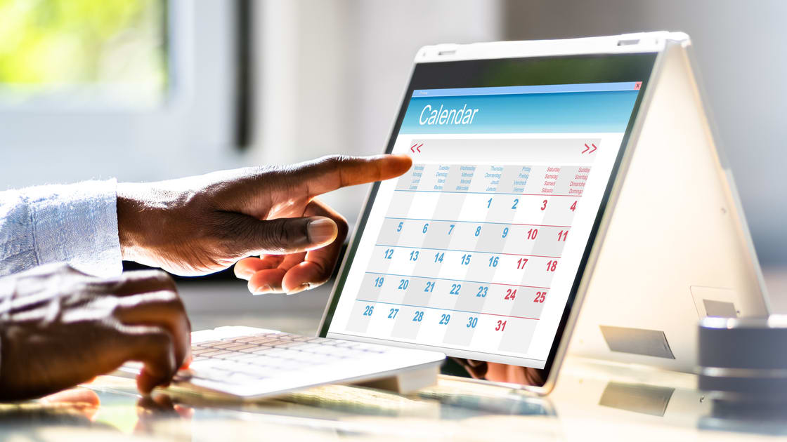 A man is using a tablet computer with a calendar on it.