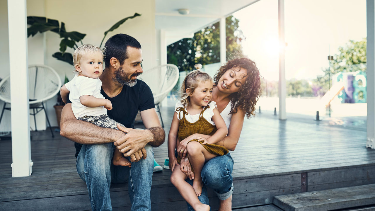 A family sits on the steps of their home.