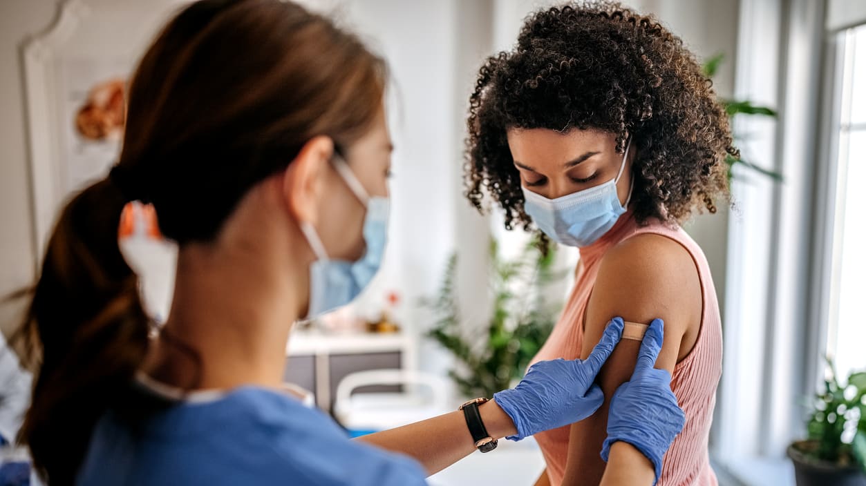 A woman is getting a vaccine in a doctor's office.