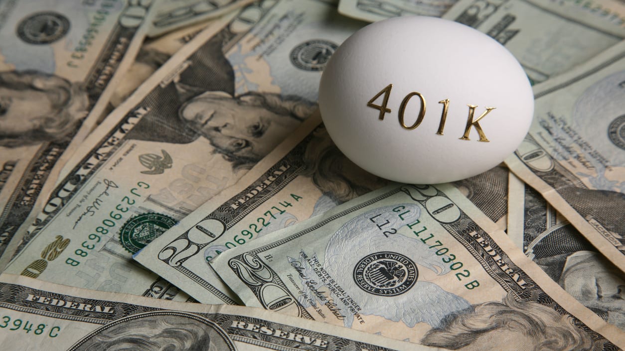 A white egg sits on top of a pile of money.
