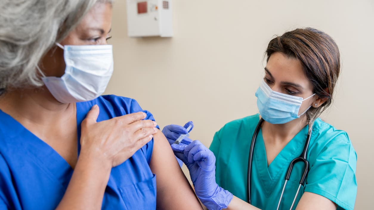 A nurse is giving a woman a vaccine.