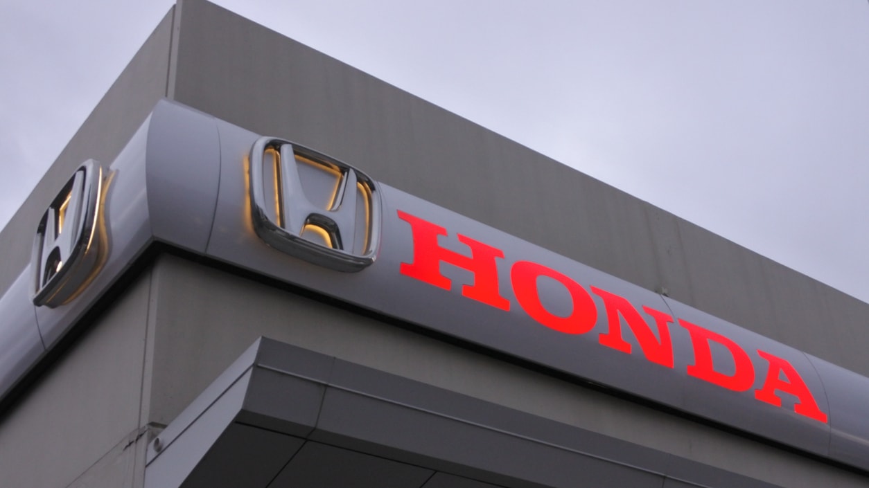 A honda dealership with a sign on it.