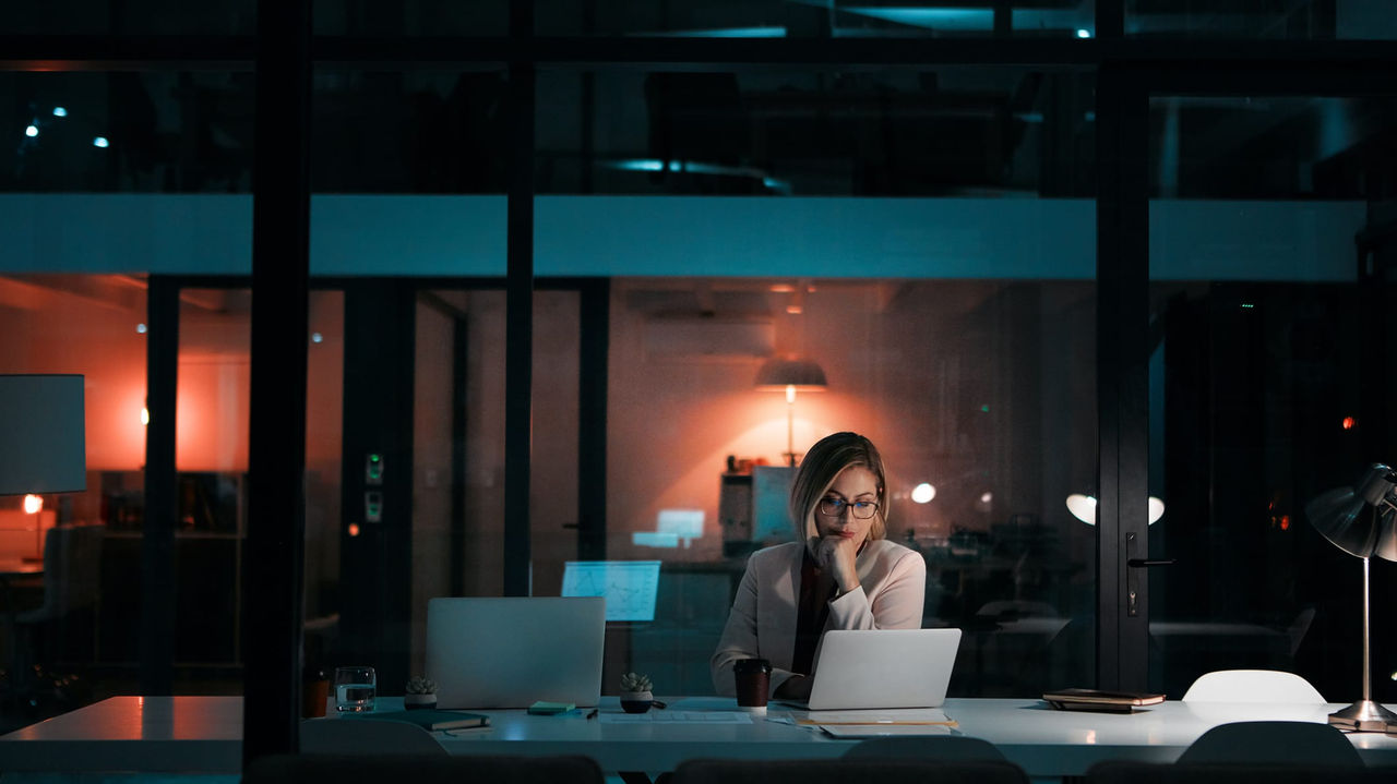 A woman working at a desk at night.