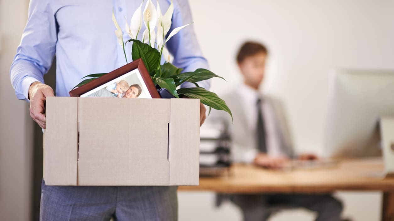 A man is holding a cardboard box with a picture in it.