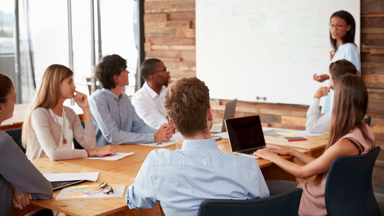 A group of people sitting around a table in a conference room.