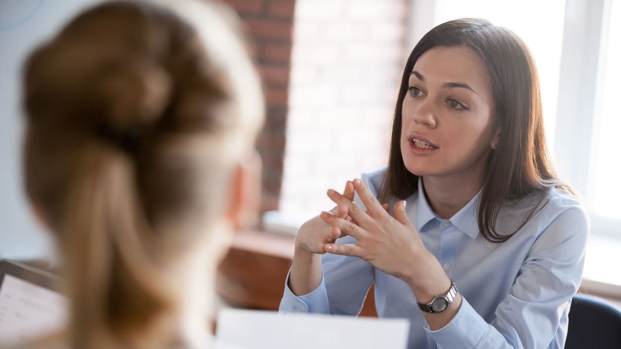 A woman is talking to another woman in an office.