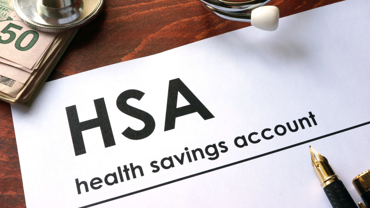 Hsa health savings account on a desk with a stethoscope and pen.