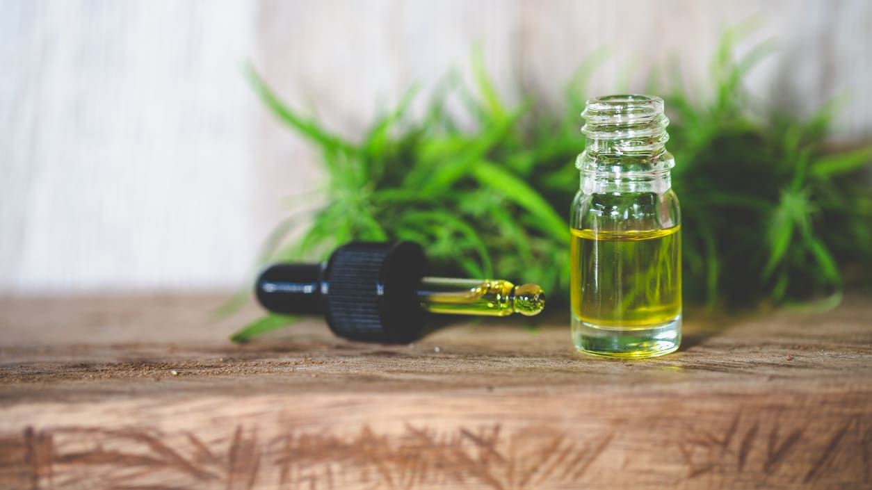 A bottle of cbd oil on a wooden table.