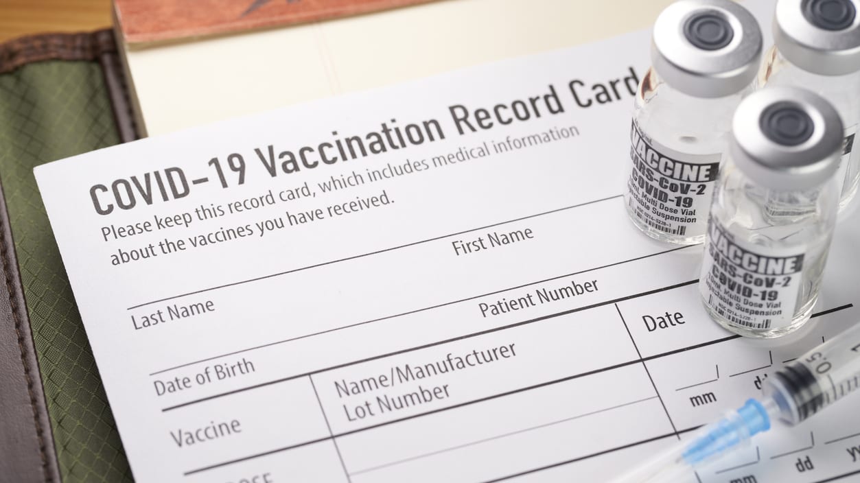 Covid-19 vaccination record card with a syringe.