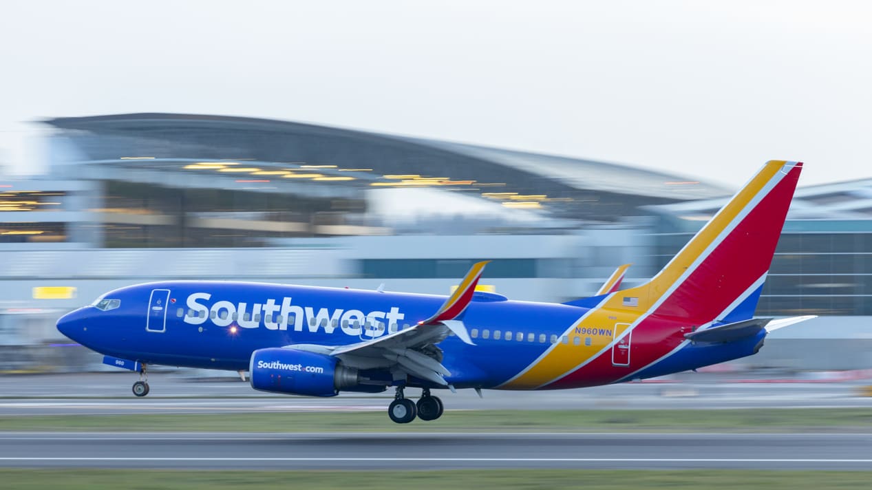 A southwest airplane is taking off from an airport.